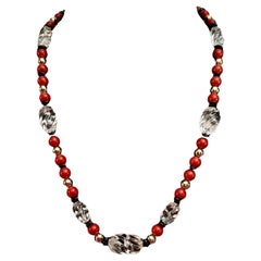Corail rouge, cristal de roche, or et rondelle d'onyx noir.
