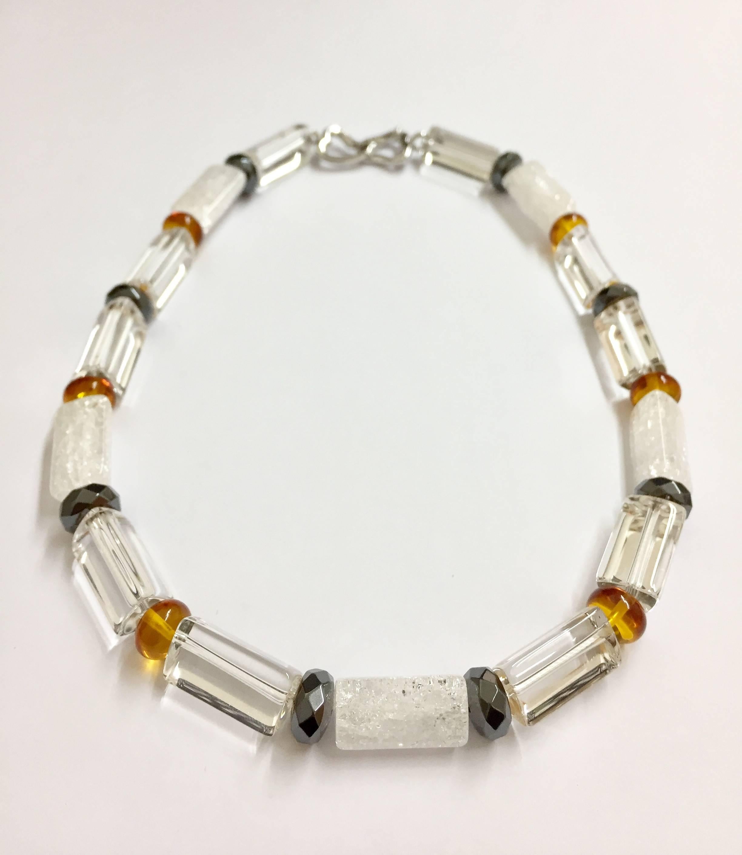 17 inch necklace with faceted crystal, natural amber and faceted hematite discs. Sterling silver 18K white gold plated hook.
