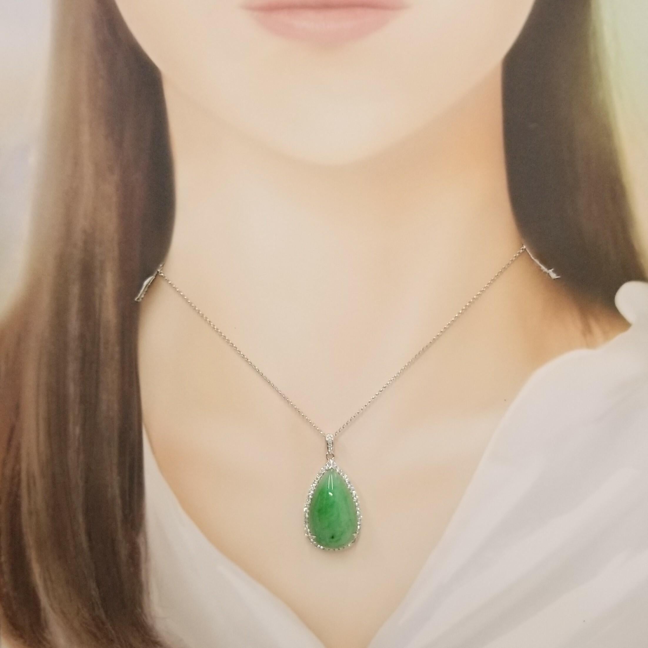 Cet élégant pendentif est un mélange captivant de beauté naturelle et d'éclat raffiné, méticuleusement réalisé en or blanc 18 carats lustré. En son cœur se trouve un magnifique cabochon de jade en forme de larme, présentant une délicate teinte 