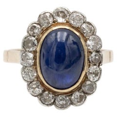 Antique ring with a cabochon-cut sapphire and old-cut diamond halo.