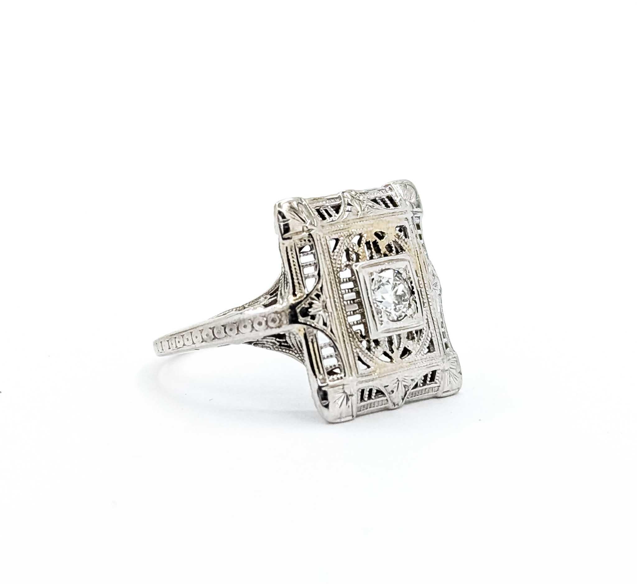 Ti presentiamo questo squisito anello realizzato in oro bianco 18 carati, caratterizzato da un delicato design in filigrana che emana un'eleganza senza tempo. Al centro di questo gioiello si trova uno splendido diamante da 0,10 carati, incastonato