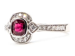 Bague « halo » en platine, sertie de rubis et de diamants, avec bordure milgrain