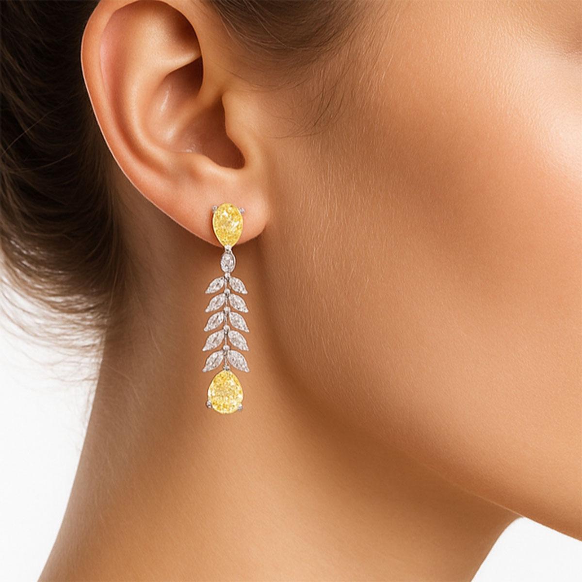 Faites tourner les têtes avec ces étonnantes boucles d'oreilles poires dorées, fusion parfaite de l'élégance intemporelle et de l'éclat moderne. Avec des pierres jaunes rayonnantes en forme de poire aux deux extrémités et une cascade de cristaux