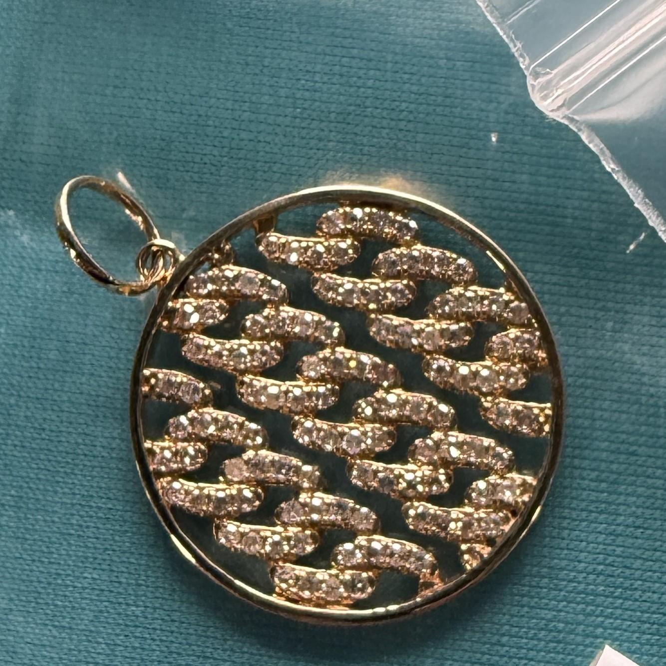 Rayonnant d'élégance et de symbolisme, ce collier à pendentif médaillon présente un motif ajouré magnifiquement détaillé, suspendu à une chaîne en or jaune 14 carats finement ouvragée. Le médaillon complexe de style filigrane ajoute une touche