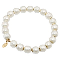 Bracelet CHANEL à breloques logo doré, orné de perles synthétiques et de perles en fil