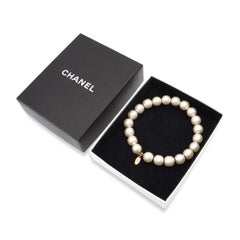 Bracelet CHANEL à breloques logo doré, orné de perles synthétiques et de perles en fil