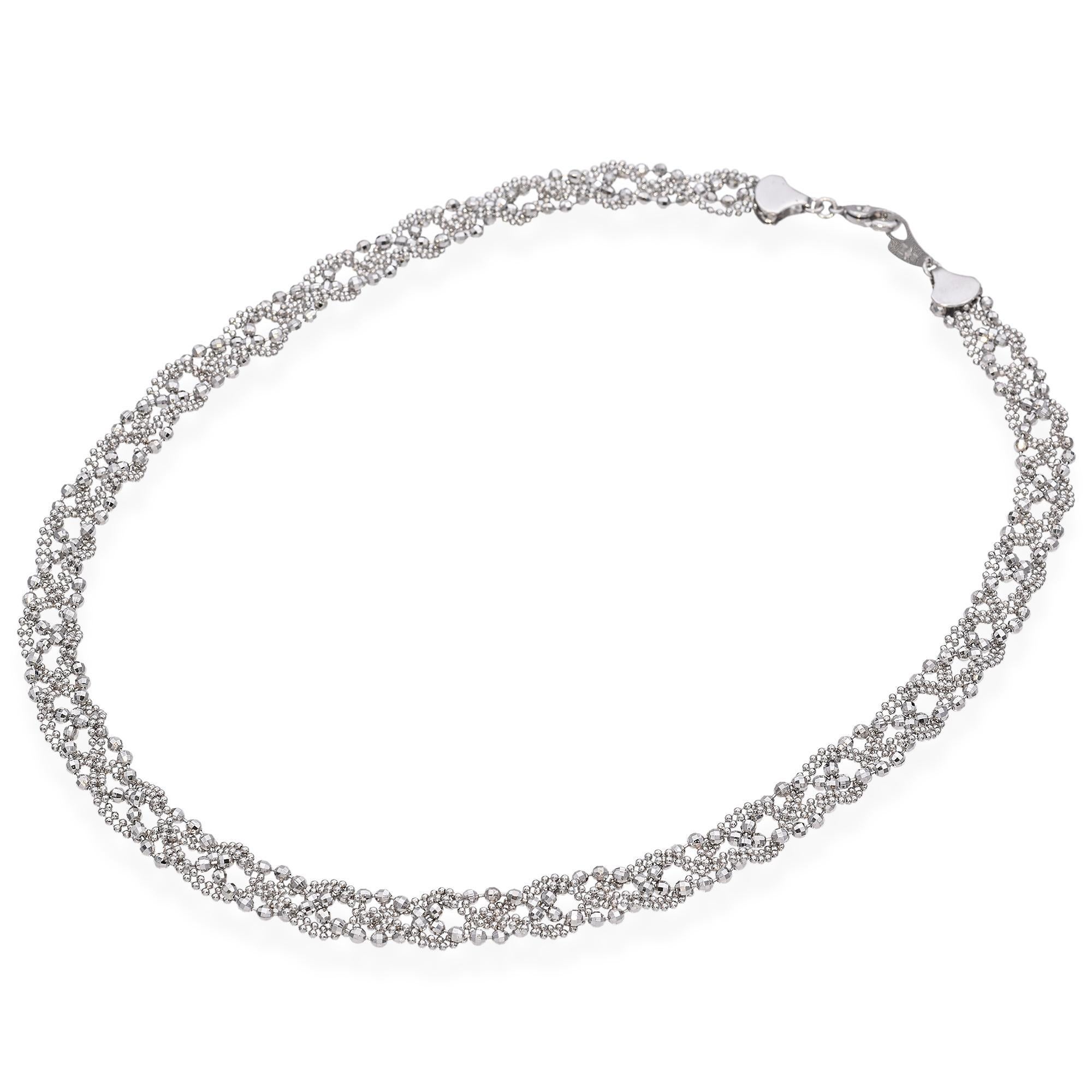 Questo pezzo presenta un intricato disegno di perline di platino tagliate a diamante intrecciate, che creano un aspetto delicato e strutturato. Le perline formano un motivo continuo ed elegante per tutta la collana. La chiusura è a gancio, semplice