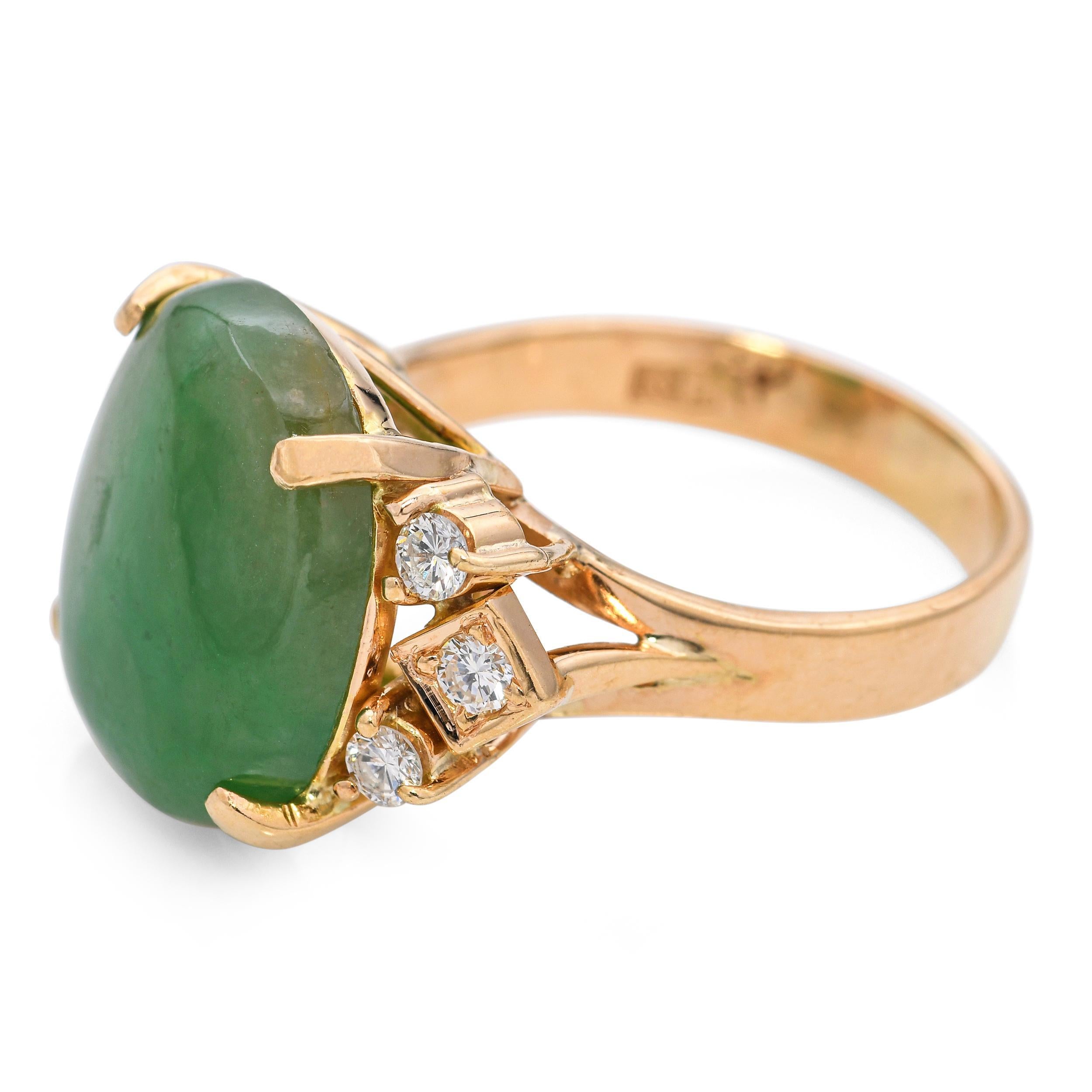 Cette élégante bague vintage présente un centre en jade magnifiquement poli, serti dans un riche or jaune 18 carats, rehaussé de diamants étincelants qui ajoutent une touche raffinée de brillance. La teinte vert vif du jade contraste gracieusement