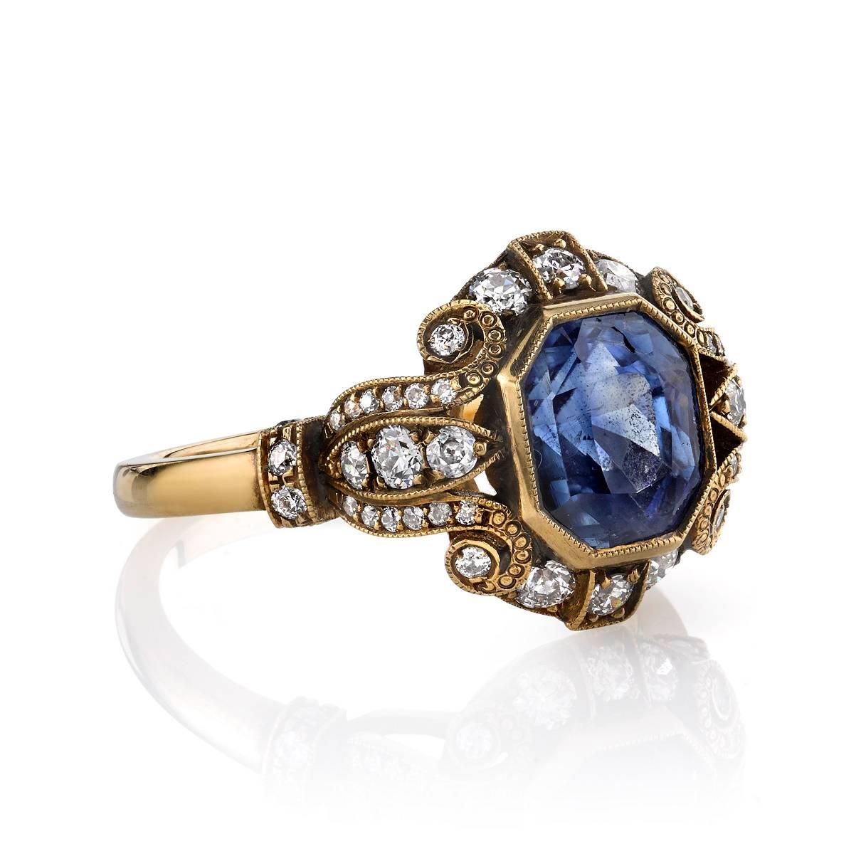 2.52ct Sapphire set in a handcrafted 18k oxidized yellow gold mounting. An Art Deco design featuring a bezel set diamond and beautiful scroll work.