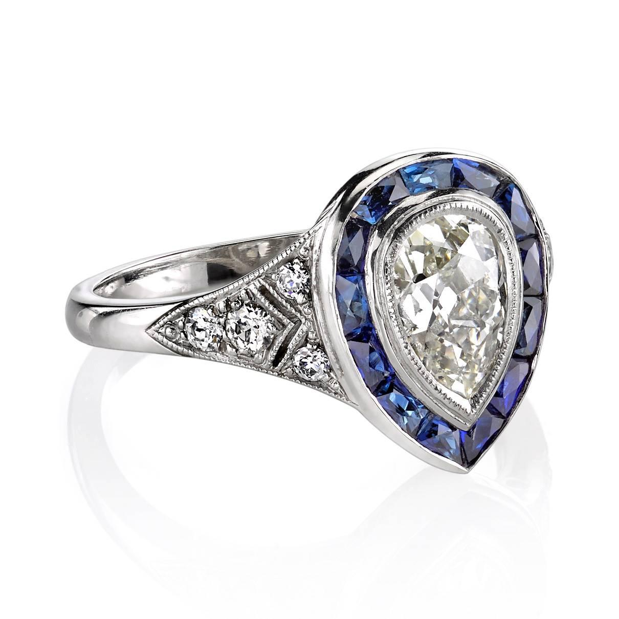 1.12ct I/VS1 EGL certified Pear shape diamond set in a handcrafted platinum mounting. A beautiful low profile design featuring intricate side details and a French cut sapphire halo.