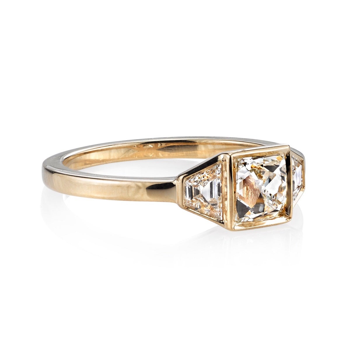 0.76ct I/VS vintage Cushion cut diamond set in a handcrafted 18K yellow gold mounting. A clean and classic design featuring trapezoid accent diamonds.