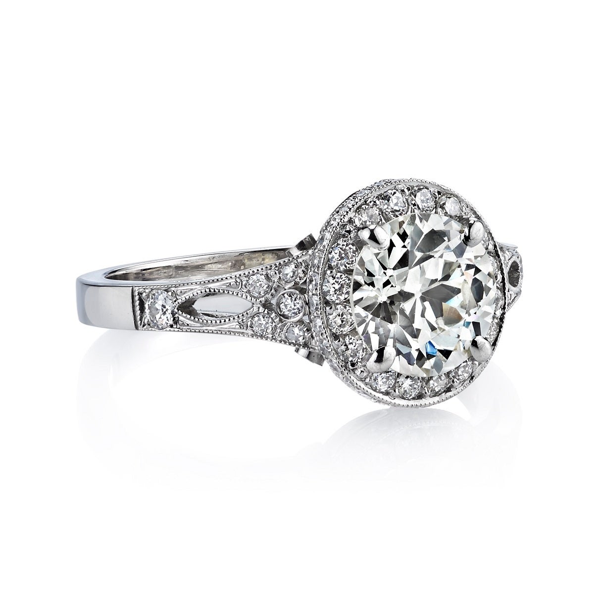 1.56ct L/SI1 EGL certified old European cut diamond set in a handcrafted platinum mounting. A classic halo design that is prong set and features filigree.