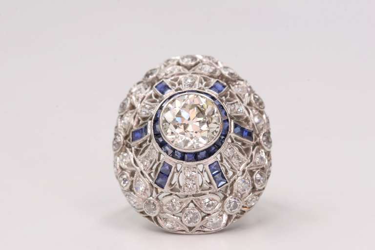 2.20ct L/SI2 old European cut diamond with 1.10cttw sapphire accents set in a vintage platinum mounting. Circa 1920