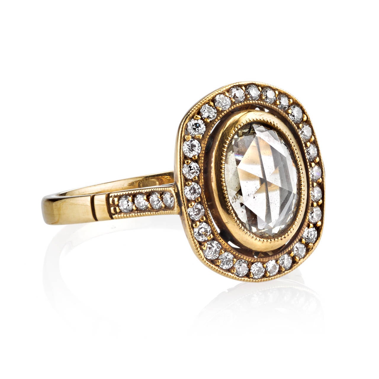 0.81ct LM/SI2 oval Rose cut diamond set in a handcrafted 18k oxidized yellow gold mounting. A halo design featuring a bezel set diamond, low profile, and intricate gallery.