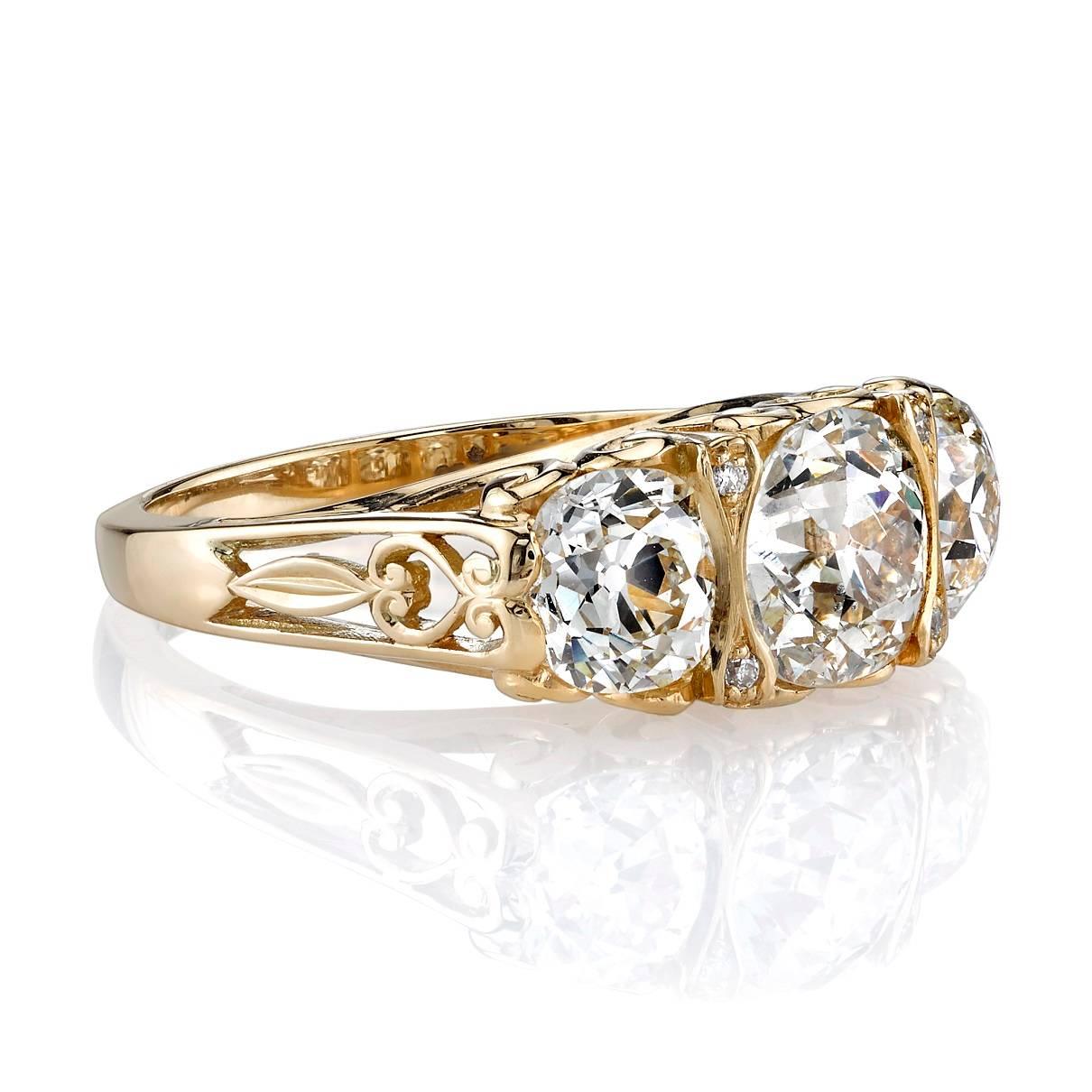 1.47ct J/SI2 vintage Cushion cut diamond with 1.54ctw vintage cushion cut accent stones set in a handcrafted 18K yellow gold three stone mounting. This ring features beautiful scroll work and intricate side detail. 
