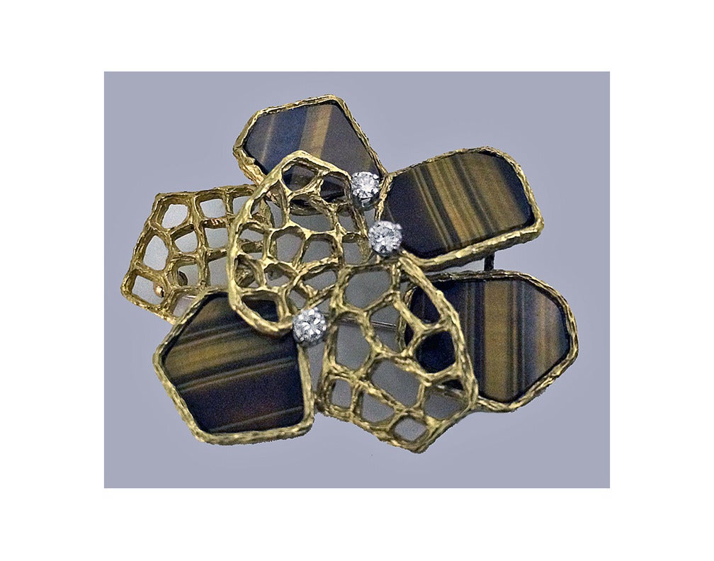 English 18ct, Diamond and tigers eye Pendant brooch, Hallmark 1972. The brooch of abstract design alternating flat tigers eye and open bark florentine finish links, accented with three small full cut diamonds, approximately 0.20 ct, total diamond