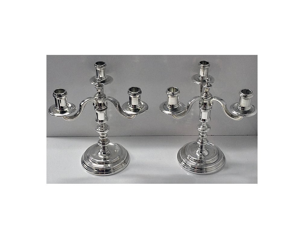 Pair of Christofle Silver plate Candelabra Candlesticks, France, C.1980. Each on circular stepped bases, knopped stems supporting three branch lights. Christofle marks. Height: 9.5 inches. Breadth: 8.5 inches.