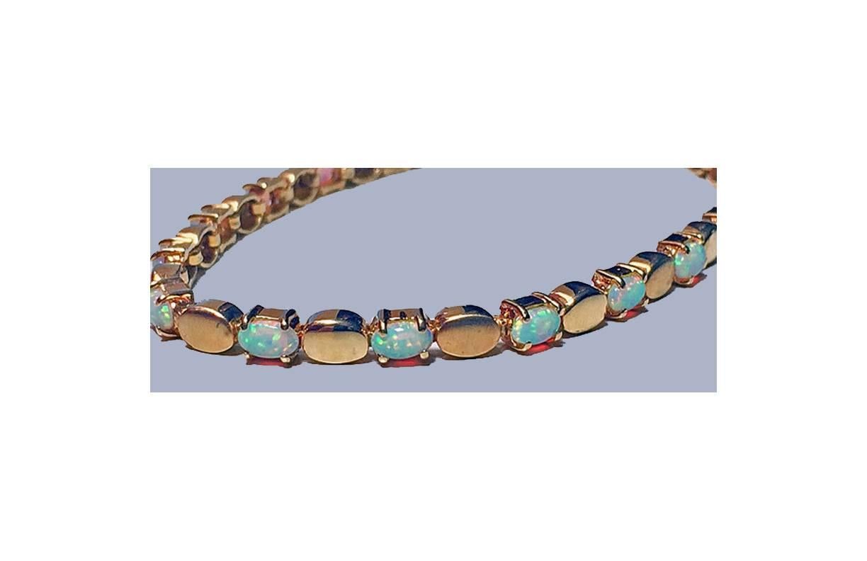 Opal and 14K yellow Gold Bracelet, London hallmarked, 20th century. The bracelet set with 16 oval opal small cabochons, interspaced with alternate small oval matte and polished gold links, terminating with lobster clasp. Opal weight: approximately