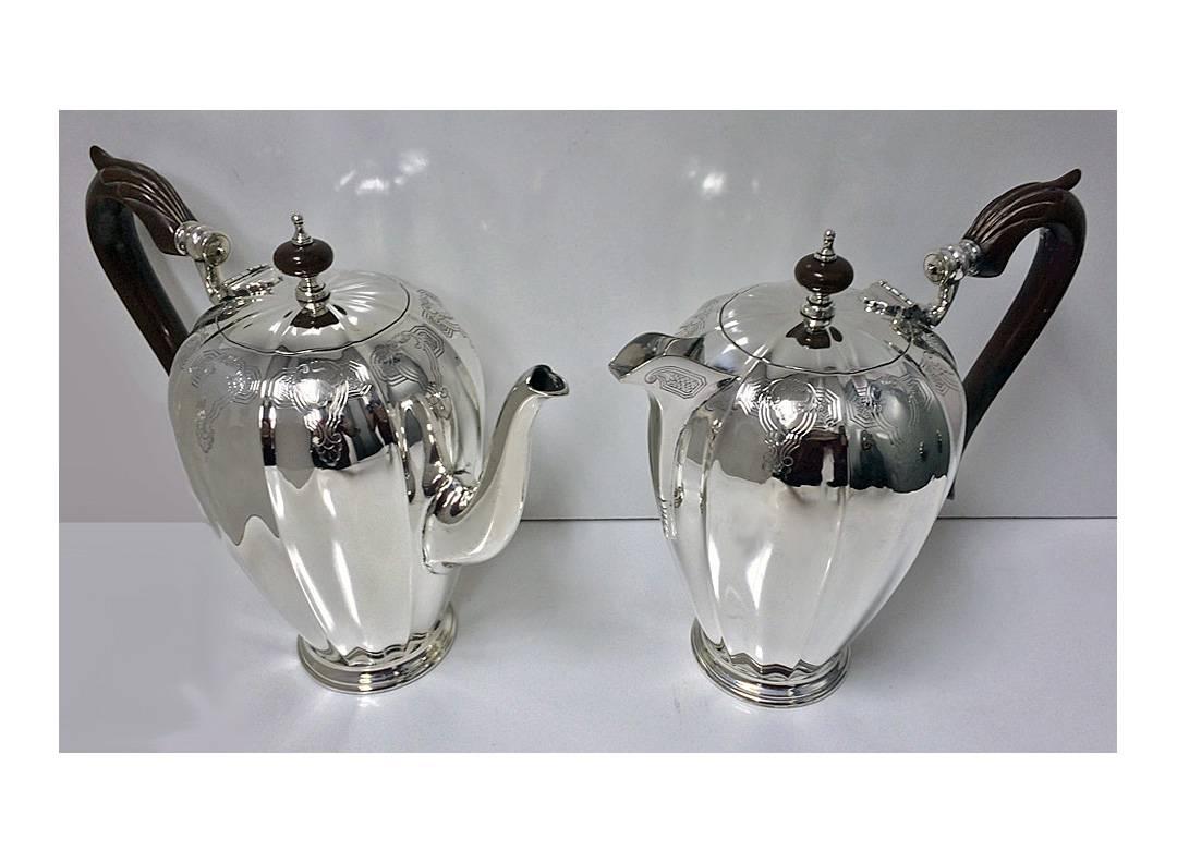 Indian Sterling silver Tea and Coffee Set, Hamilton & Co, Calcutta, C.1940. The Coffee Pot, Teapot, Hot Water, Cream and Sugar of `pumpkin' design, oval paneled body engraved foliate upper surround. The handles of pots and finials carved composite