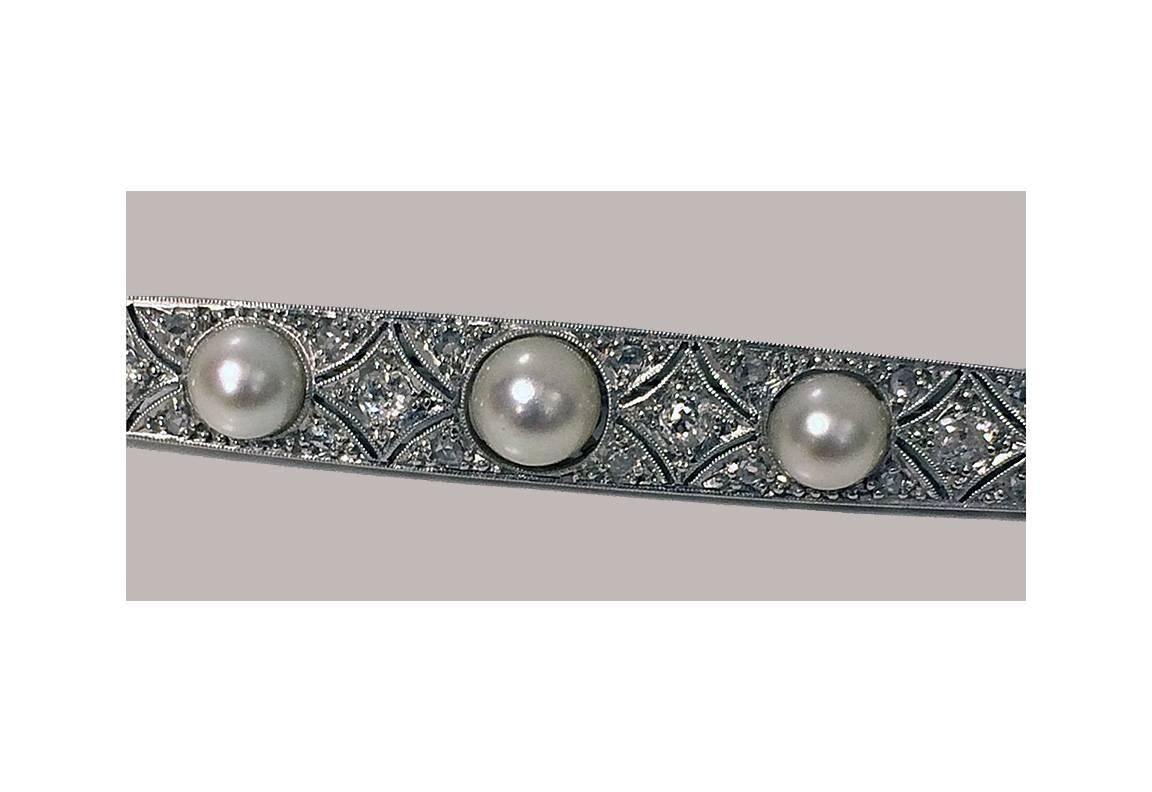 Platinum Diamond and Pearl bar Brooch, C.1920. The brooch milligrain diamond set with 28 mixed old cut diamonds, total diamond weight approximately 0.45 ct, average SI clarity, average I colour, interspaced with five graduated silver grey natural