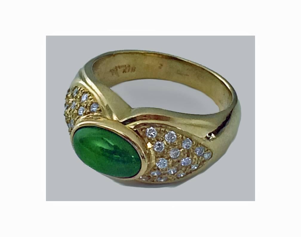 18K yellow gold Jade and Diamond Ring, C.1980. The Ring bezel set with an oval cabochon green jade, approximately 2.00 ct, the shoulders each pave set with 15 round brilliant cut diamonds, approximately 0.50 ct, total diamond weight, average VS2