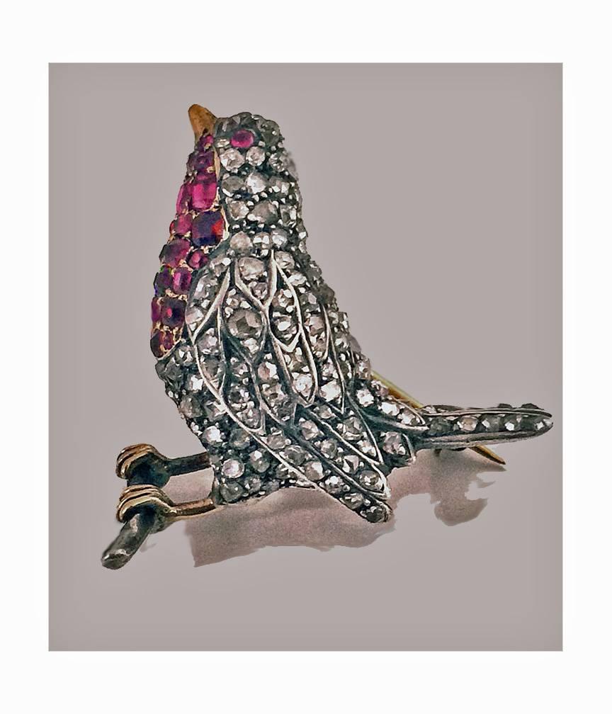 Antique Diamond and Ruby Robin redbreast Bird Brooch Pin, English C.1890. The brooch depicting a robin bird with red ruby breast perched on a gold branch, the body and head set with numerous mixed old mine and rose cut diamonds, approximately 1.00