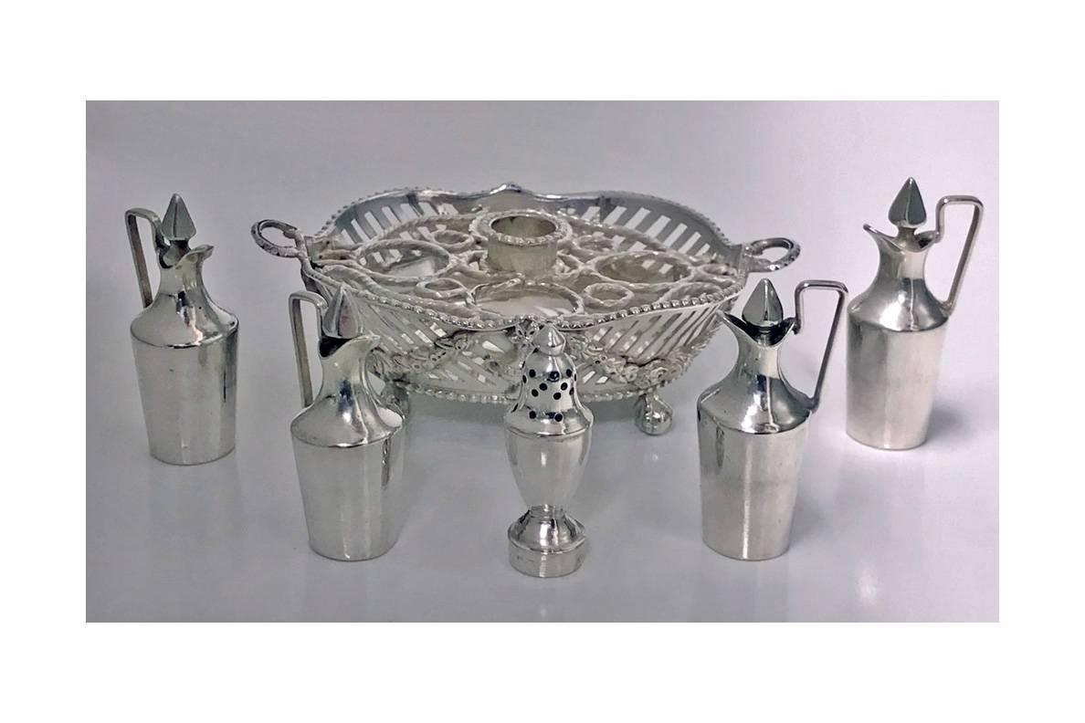 A Dutch silver Miniature Toy Cruet Stamped IO and with a circlet, 19th century. Oval and on four ball and claw feet, the sides pierced and chased with swags, with supports for four bottles and with central tapering caster, marked underneath and on