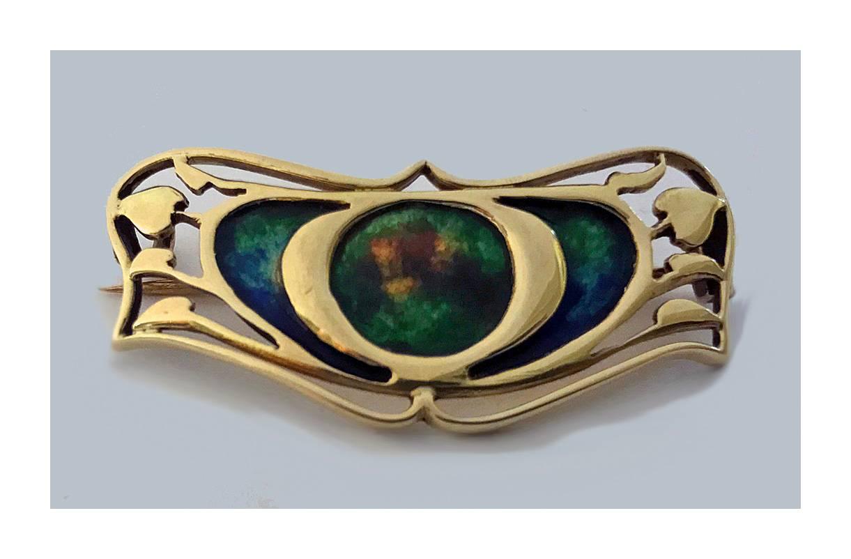 Gold Enamel Art Nouveau Brooch, attributed Archibald Knox for Liberty, C.1900. The brooch of open 15K gold foliate stylised form with green, blue and orange enamel. Measures: 1.5 x 5/8 inches. Weight: 4.98 grams. 