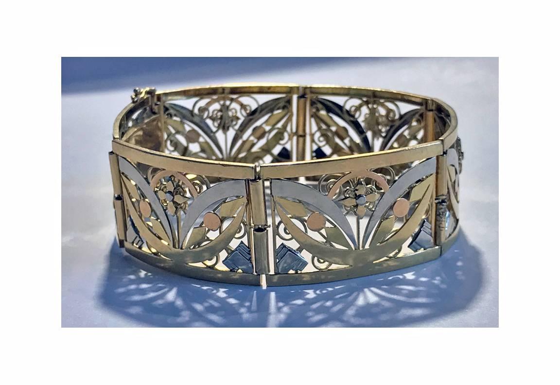 French 18K Art Nouveau three colour gold Bracelet, C.1900. The bracelet with six slightly convex pierced open stylised foliate hinged sections, terminating with tongue and box clasp fastener, safety catches attached. French marks and maker’s mark SR