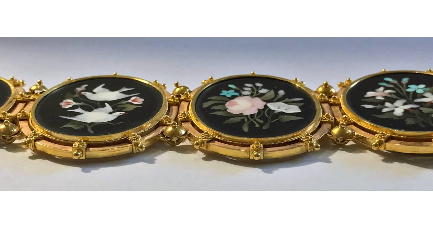 Antique 19th century Italian large oval Pietra Dura Bracelet, C.1875. The bracelet comprising six large oval panels with pietra dura floral design depicting colorful flowers, birds and foliage, against the rich black background. The surround mount