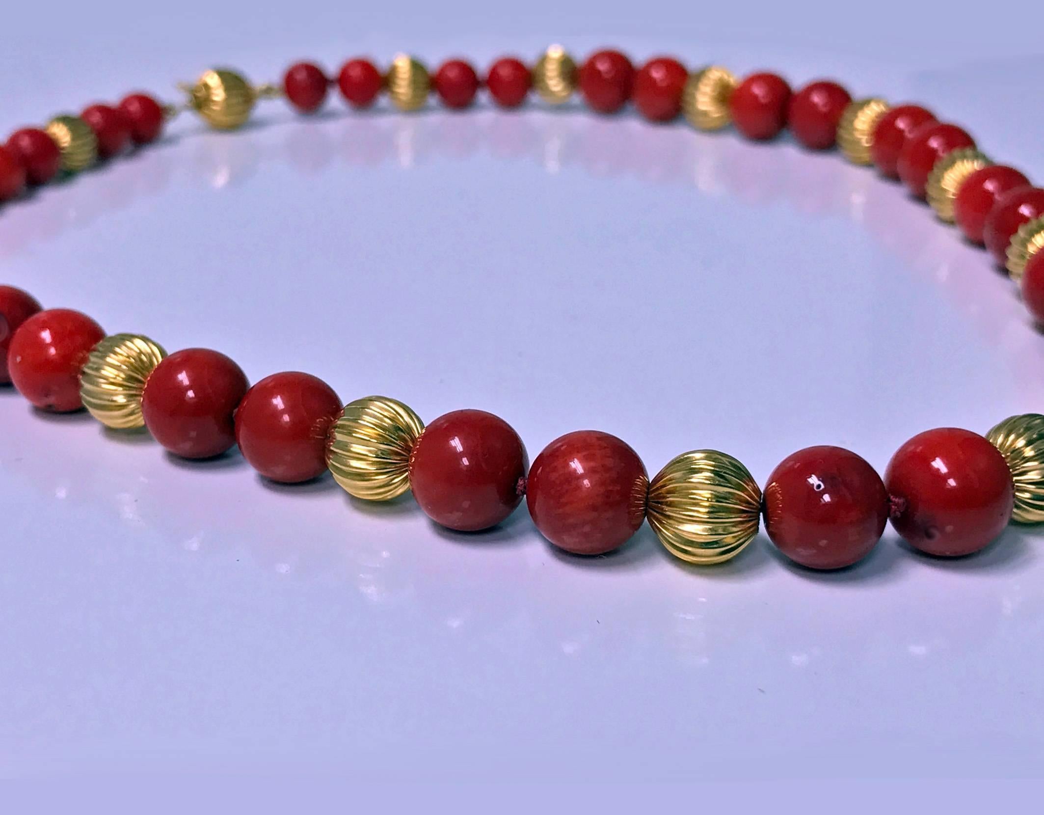 Natural untreated undyed red coral color bead and Gold Necklace, 20th century. The necklace comprising 24 round natural red coral color beads gauging approximately 8.80 - 9.20 mm and an end extension of a further 8 dyed red beads, approximately 7.00