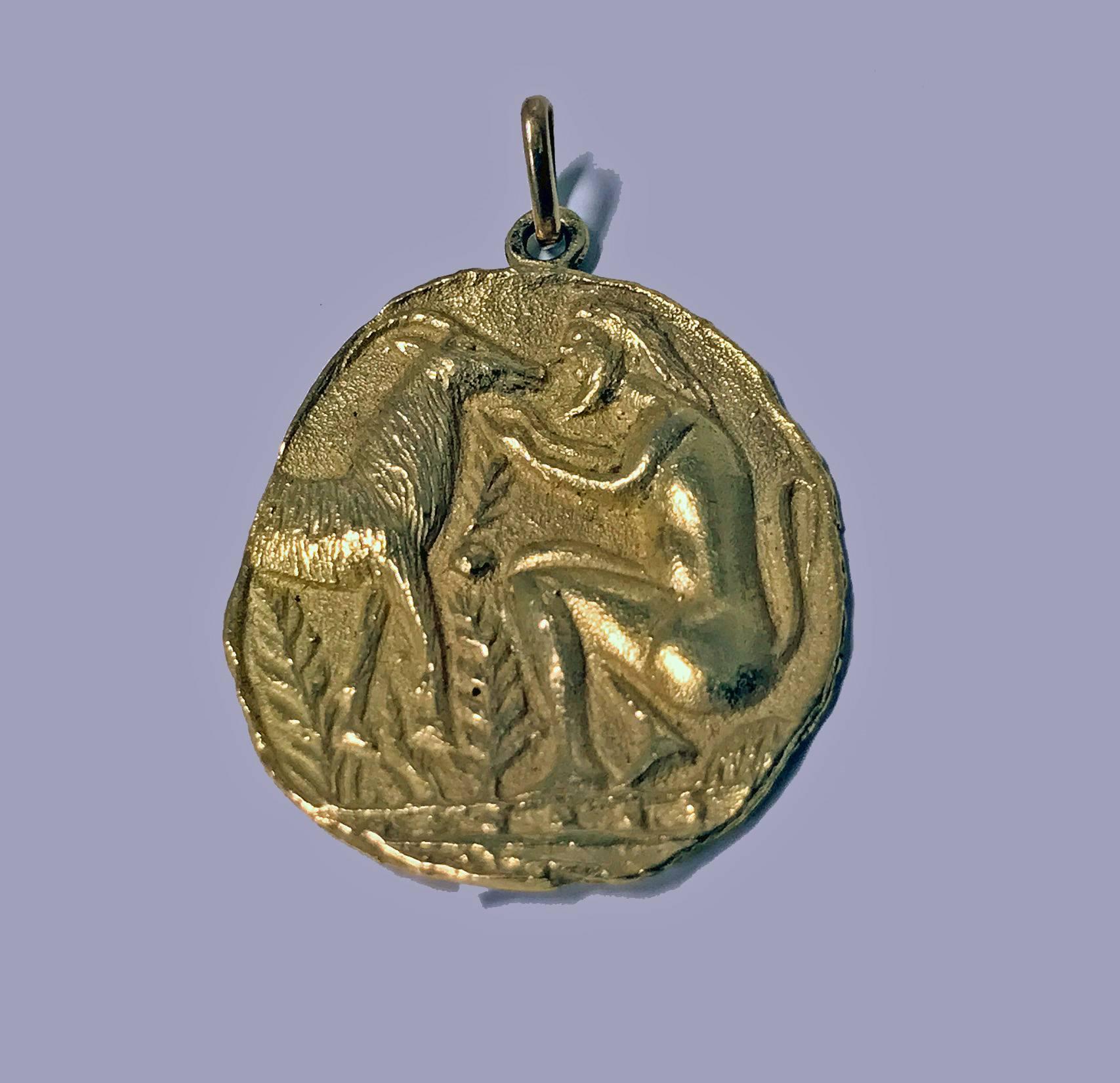 18K Yellow Gold Pendant medallion depicting seated mythological beast with an antelope. Stamped K18 on reverse. Measures: Approximately 1.25 x 1.00 inches. Item Weight: 4.25 gm.