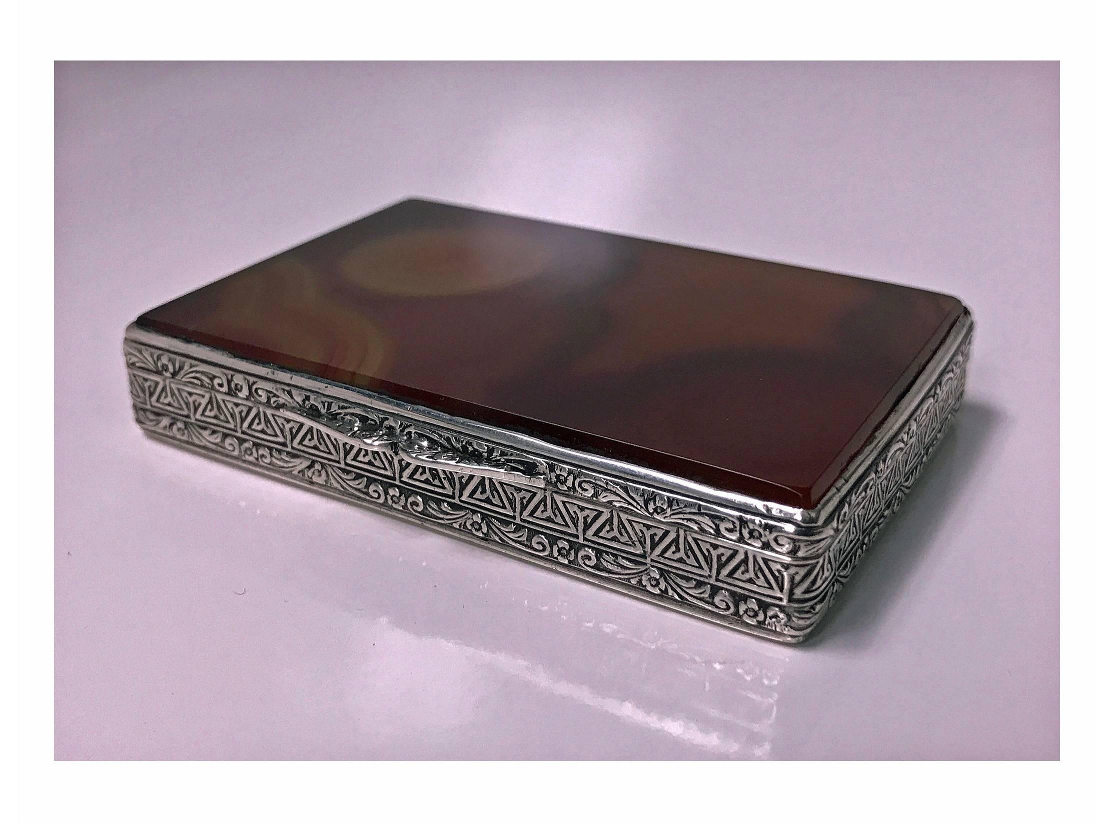 Fratelli Cacchione Agate and Silver Box Case, Italy, C.1955. The rectangular box with banded orange and brown agate cover, the surround of scroll and foliage design, the base of alternate lozenge and wriggle work decoration. Hallmarked on interior
