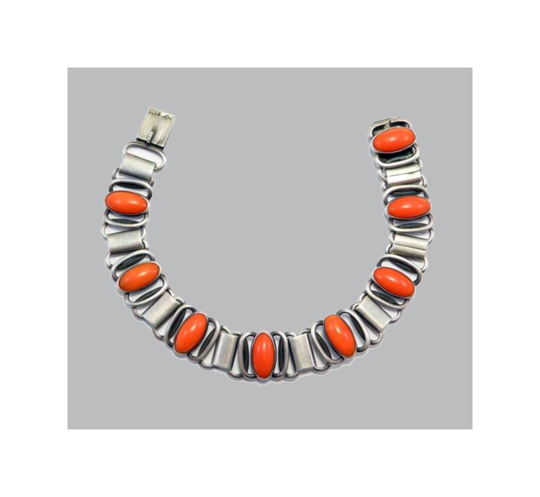Arts and Crafts Danish Silver and Coral Bracelet, Hugo Grun, C.1920. The Bracelet with eight oval bezel set medium to dark pink natural cabochon coral sections, gauging approximately 12.0 x 6.0 mm, with surround of oval and tubular links,