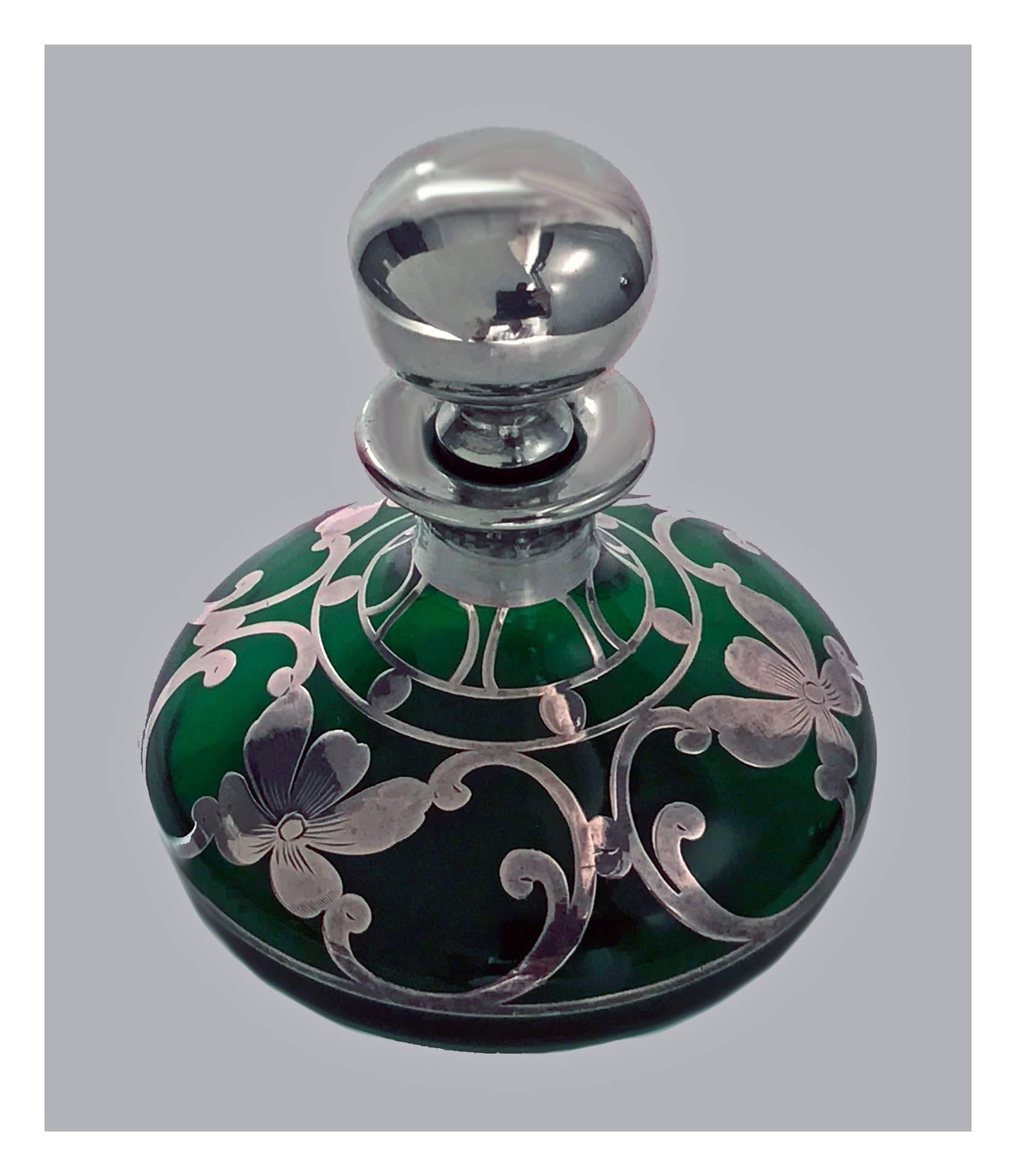 Art Nouveau green glass Perfume Bottle with Sterling Silver overlay, probably American C.1900. The perfume bottle of squat bulbous tapering form, thickly applied silver foliate overlay, plain bulbous stopper with faint monogram, not discernible.