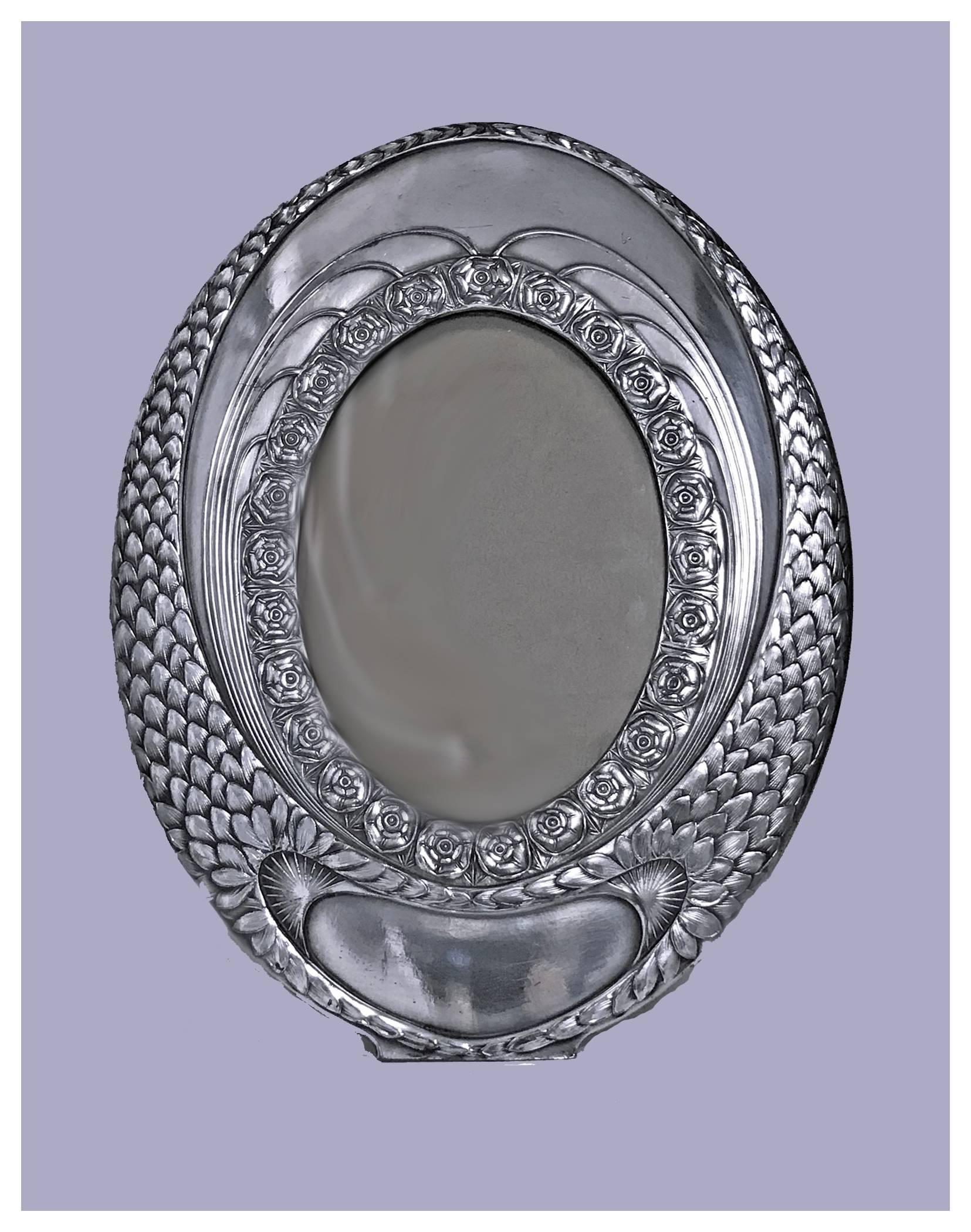 W.M.F Art Nouveau Silver Plate Frame, Germany C.1910. The Frame of large oval shape, decorated with stylised plumage and rosette design with vacant cartouche, centering an oval compartment for photograph. WMF marks. Original back. Measures:10 x 7.5