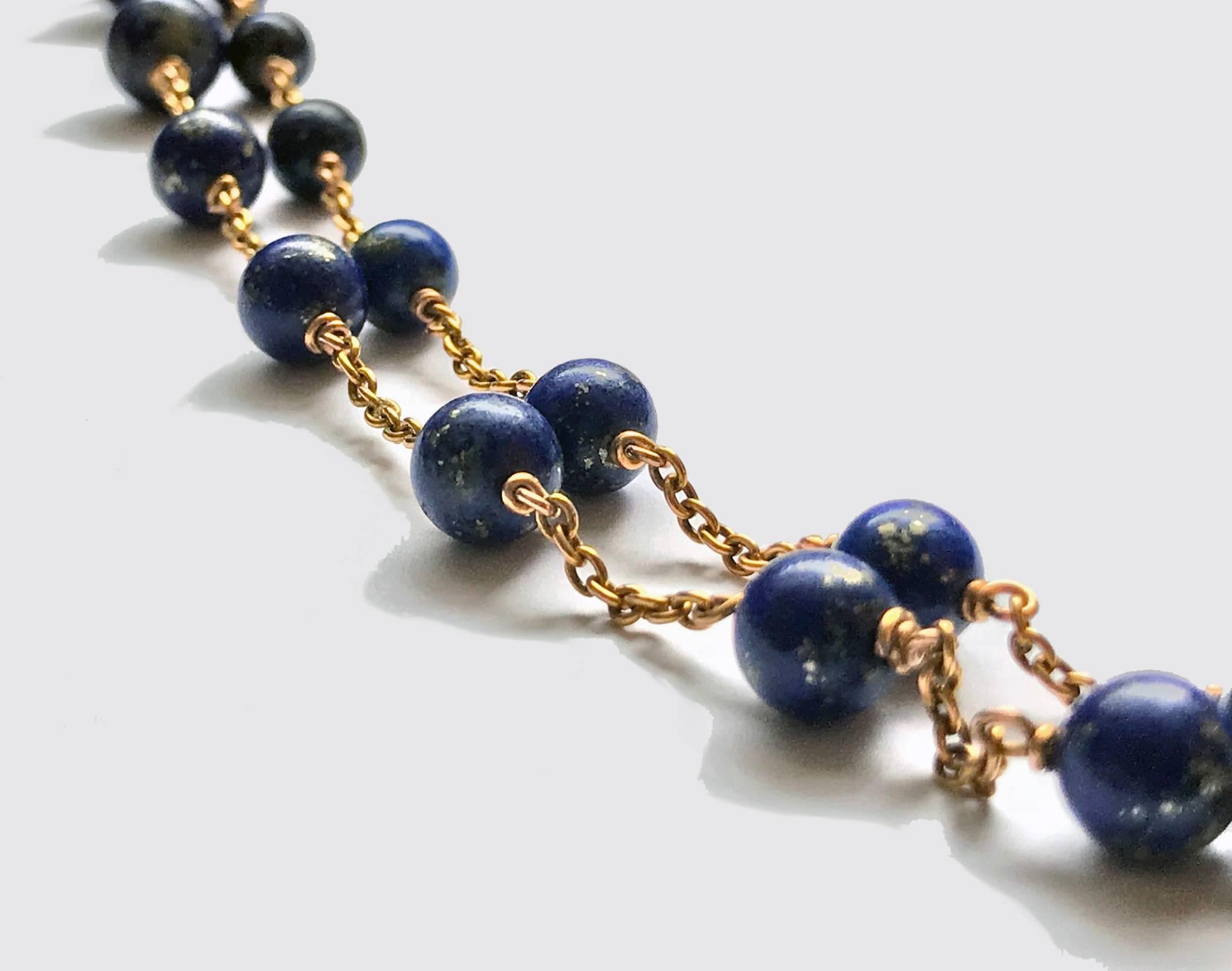 19th century Lapis lazuli and Gold Necklace. The Necklace comprising fifty three lapis lazuli beads gauging approximately  5.00 – 8.70 mm, dark blue with pyrite inclusions, 15K gold curb link chain between, terminating with spring ring fastener
