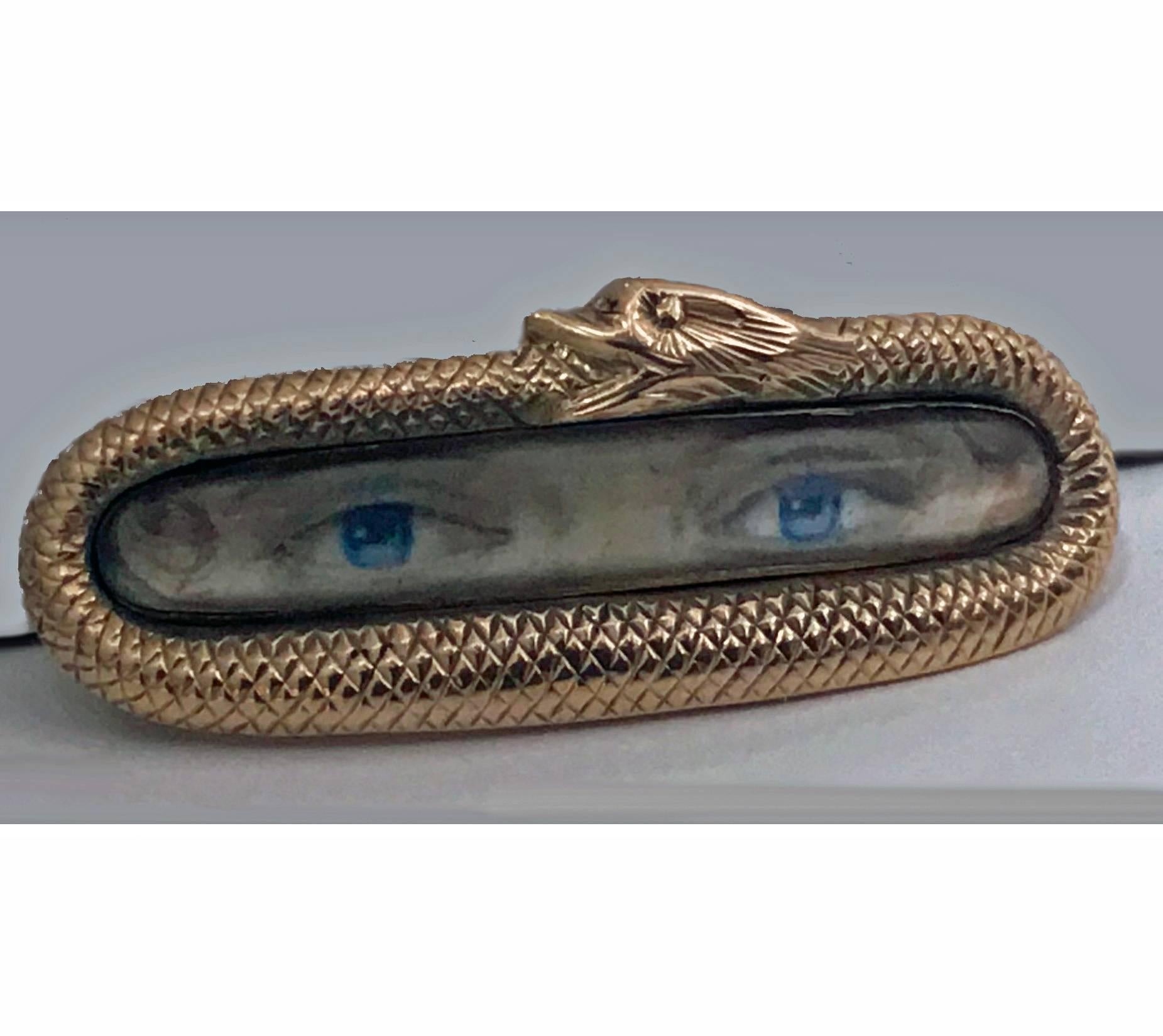 Rare Georgian Double Lover's Eye Brooch, English C.1800. The Brooch depicting a pair of blue eyes within a gold serpent frame . Length: 1 375 inches. Replaced pin stem, minor evidence of solder, reverse with monogram.