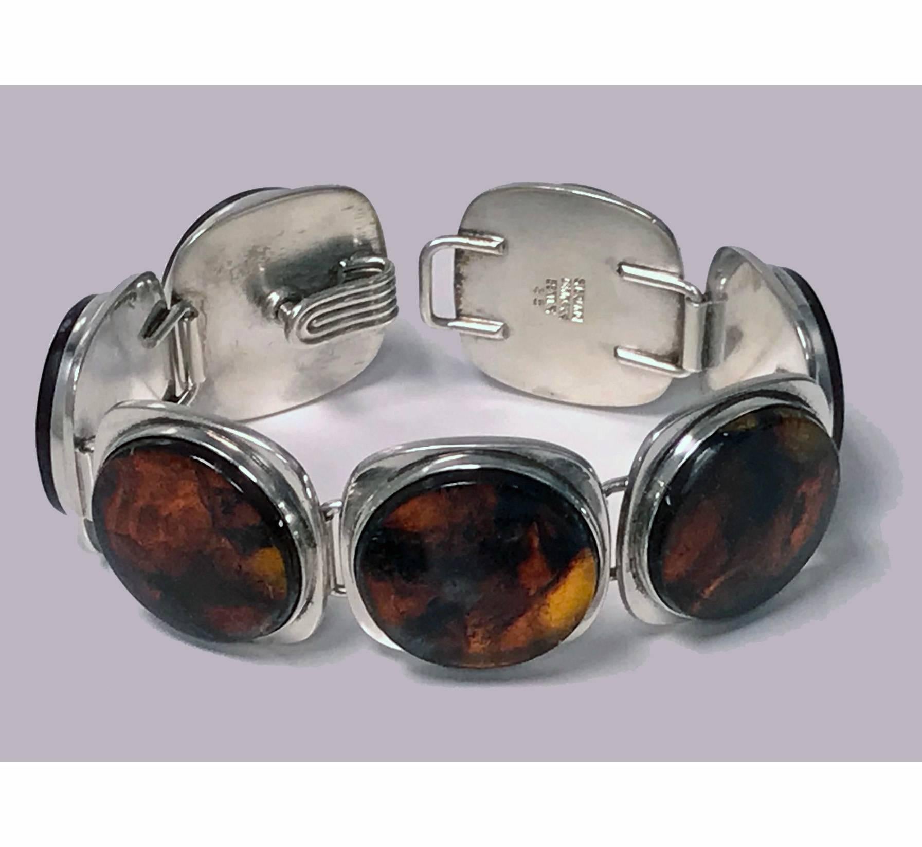 Danish mid-century Sterling Amber Bracelet and matching Earrings, Bent Knudsen C.1957. The bracelet comprising seven large round bezel set large amber stones, the end section with rotating mechanism to conform as clasp with hook fitment; together