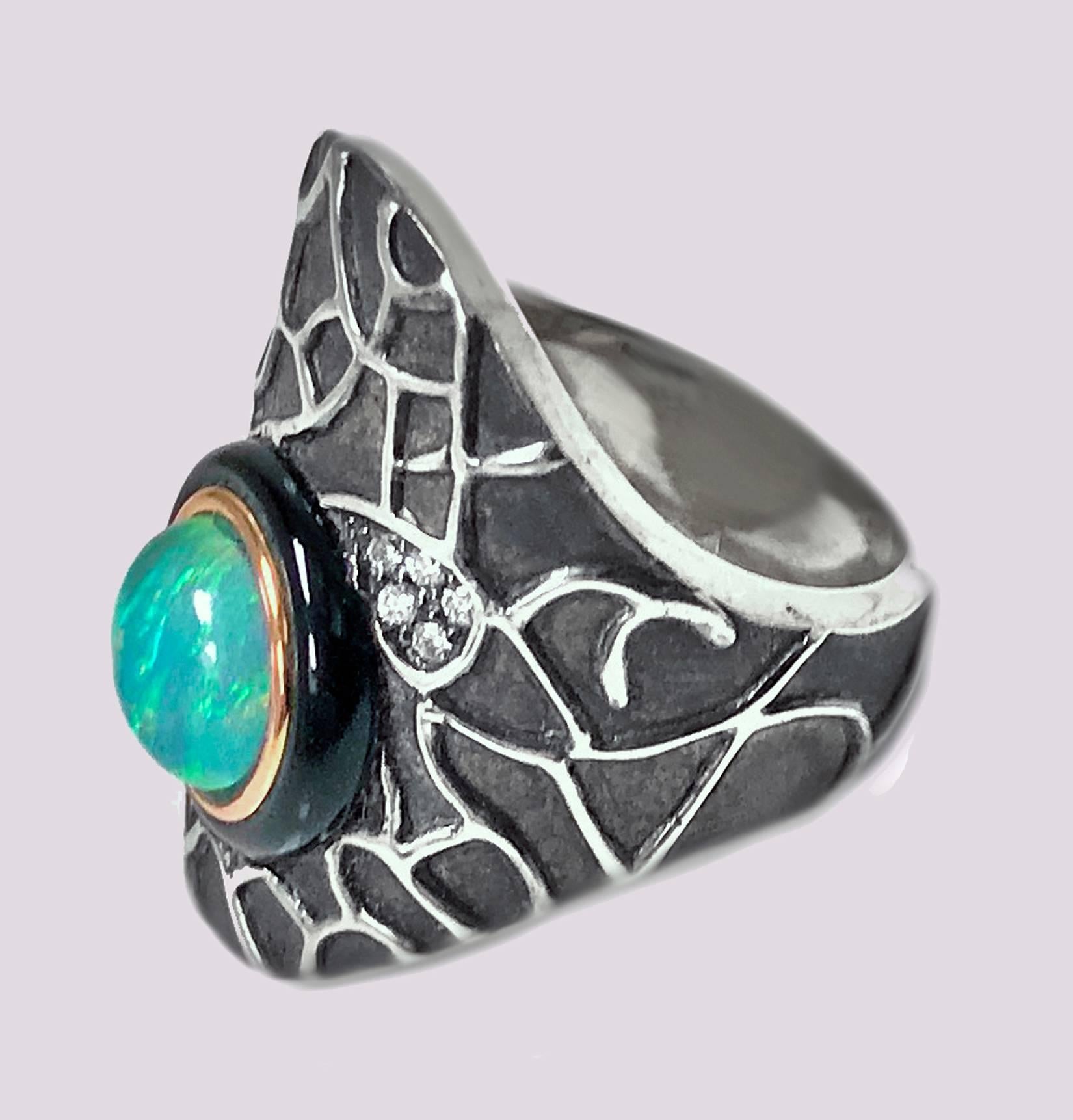 Diamond Opal Onyx Silver and Gold Ring, custom made. The of an asymmetrical shape, 18K gold bezel offset with a round opal, approximately 8.00mm, good play of colour, with outer black onyx surround. The mount of oxidised silver with applied polished