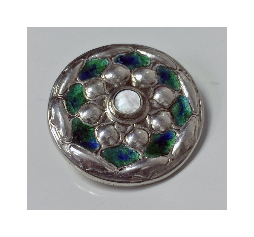 Liberty Archibald Knox Cymric Silver Enamel Brooch, Birmingham 1903. The circular Brooch with green and blue enamel and silver foliate petals, the centre set with pearl. Fully hallmarked to reverse and stamped Cymric. Diameter: 1.25 inches. Item