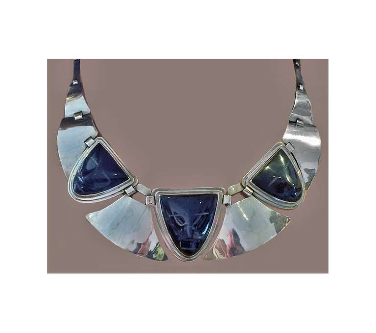 Fred Davis sterling obsidian mask Necklace, C.1930. Hand hammered sculpted elliptical form with three carved obsidian masks between links. Early mark for Fred Davis. Length: 15 ½ inches. Weight: 65.69 grams. Davis, an early collector and dealer in