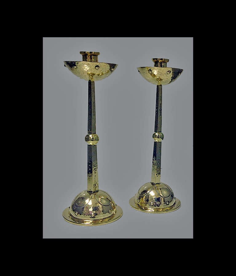 WMF Arts & Crafts Art Nouveau Jugendstil Candlesticks Germany C.1900. The brass candlesticks each on dome stylised and rivet surround hammered bases, tapered quadrilateral stems centering a bulbous sphere, the hammered nozzle supporting deep well