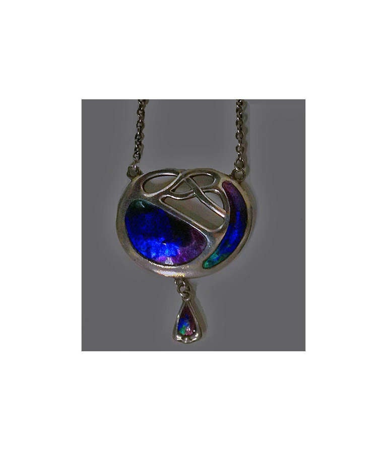 Charles Horner Enamel Pendant Necklace, Chester 1909. The celtic knot design pendant, enamelled with rich green, blue and mauve enamel variations, suspending a stylised foliate enamel section. Hallmarked for Chester 1909 by Charles Horner. Length: