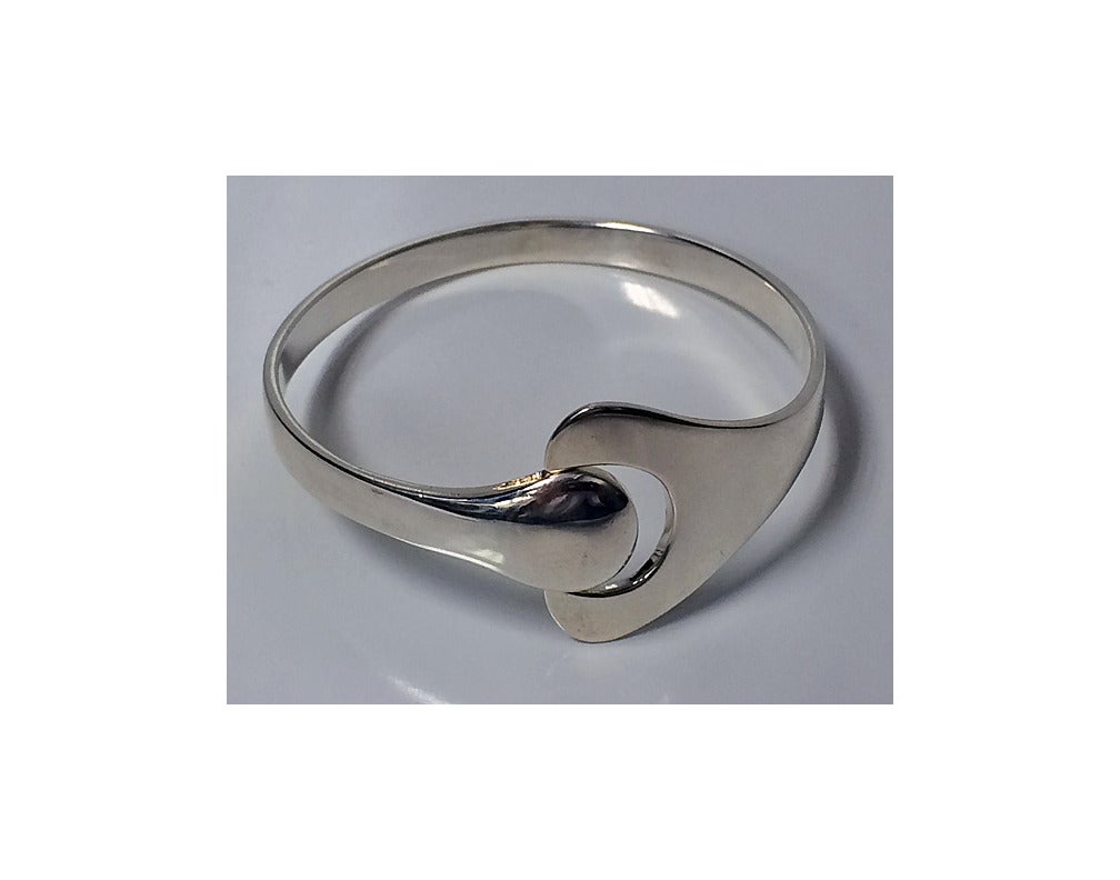 Georg Jensen Hans Hansen sterling bangle Denmark, 20th century. The bangle of offset curvilinear design. Fully marked. Small to medium wrist size. Item Weight: 37.48 grams.