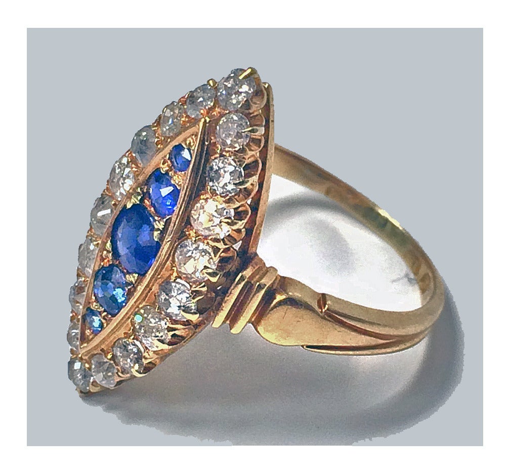 Antique Sapphire and Diamond 18K navette shape cluster Ring, English C.1896. The ring set with 5 graduated  oval facetted blue Sapphires, with a surround  of  18 old mine cut diamonds, groove shoulders, tapered shank.  Total Sapphire Weight: