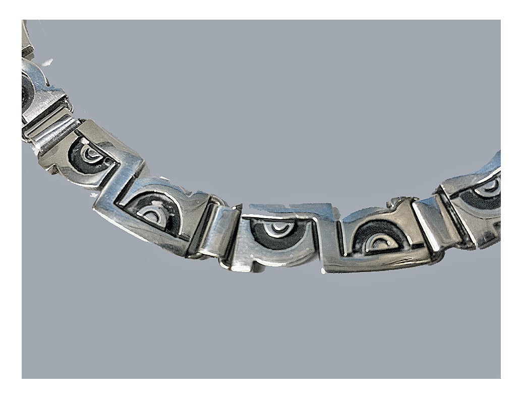 Sterling Necklace, Jose Luis Flores, Mexico, C.1970. The Necklace with Aztec style links, terminating with hook fastener. Stamped JLF for Jose Flores, 925S Taxco Mexico. Length: Approximately 17 inches. Total Item Weight: 67.81 grams.
