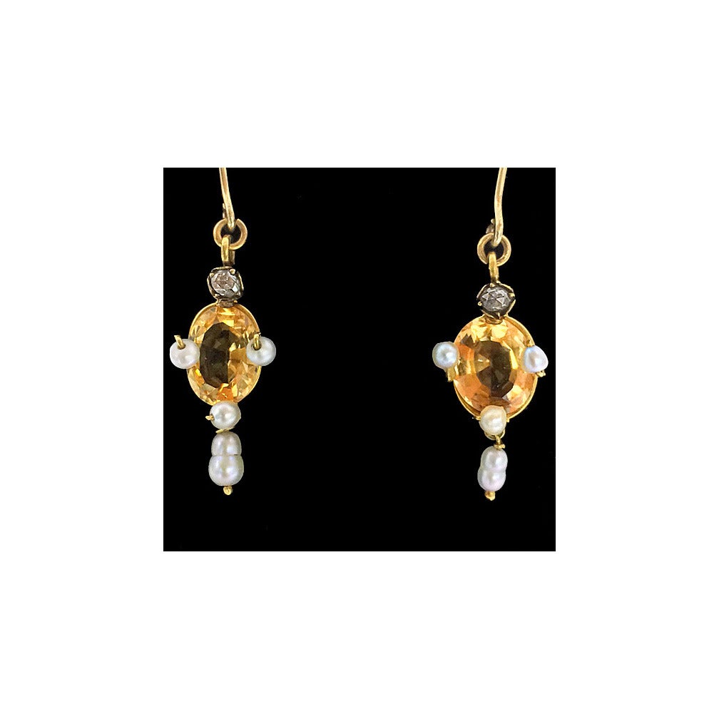 Pair of Antique imperial Topaz, Pearl, Diamond and 15K (tested) Earrings, English C.1890. Each suspending two drops of imperial yellow orange oval facetted topaz bordered with three fresh water pearls and surmounted with a small old cut diamond,