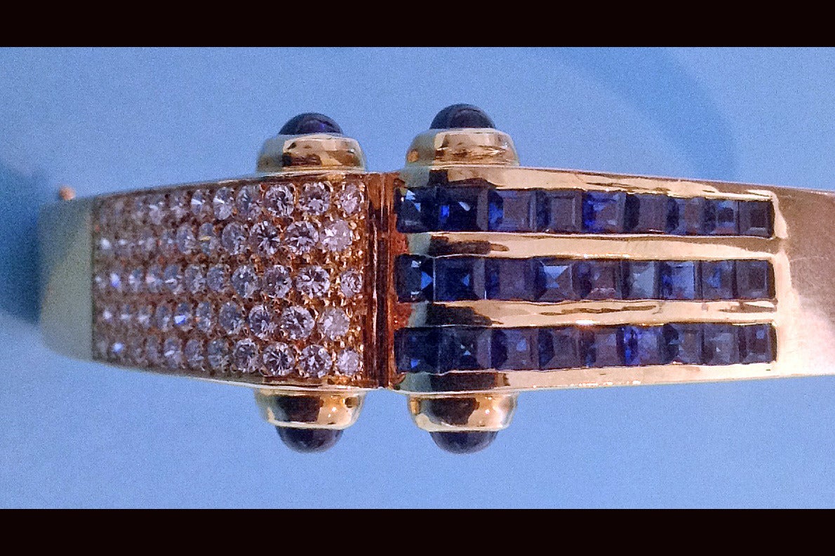 Pair of 18K Diamond and Sapphire clip Earrings together with matching Bangle bracelet. The earrings solid 18K polished yellow gold. Item weight approx. 18.7 grams. Measures 22mm x 17mm.  One earring pave set with 33 round brilliant cut diamonds,