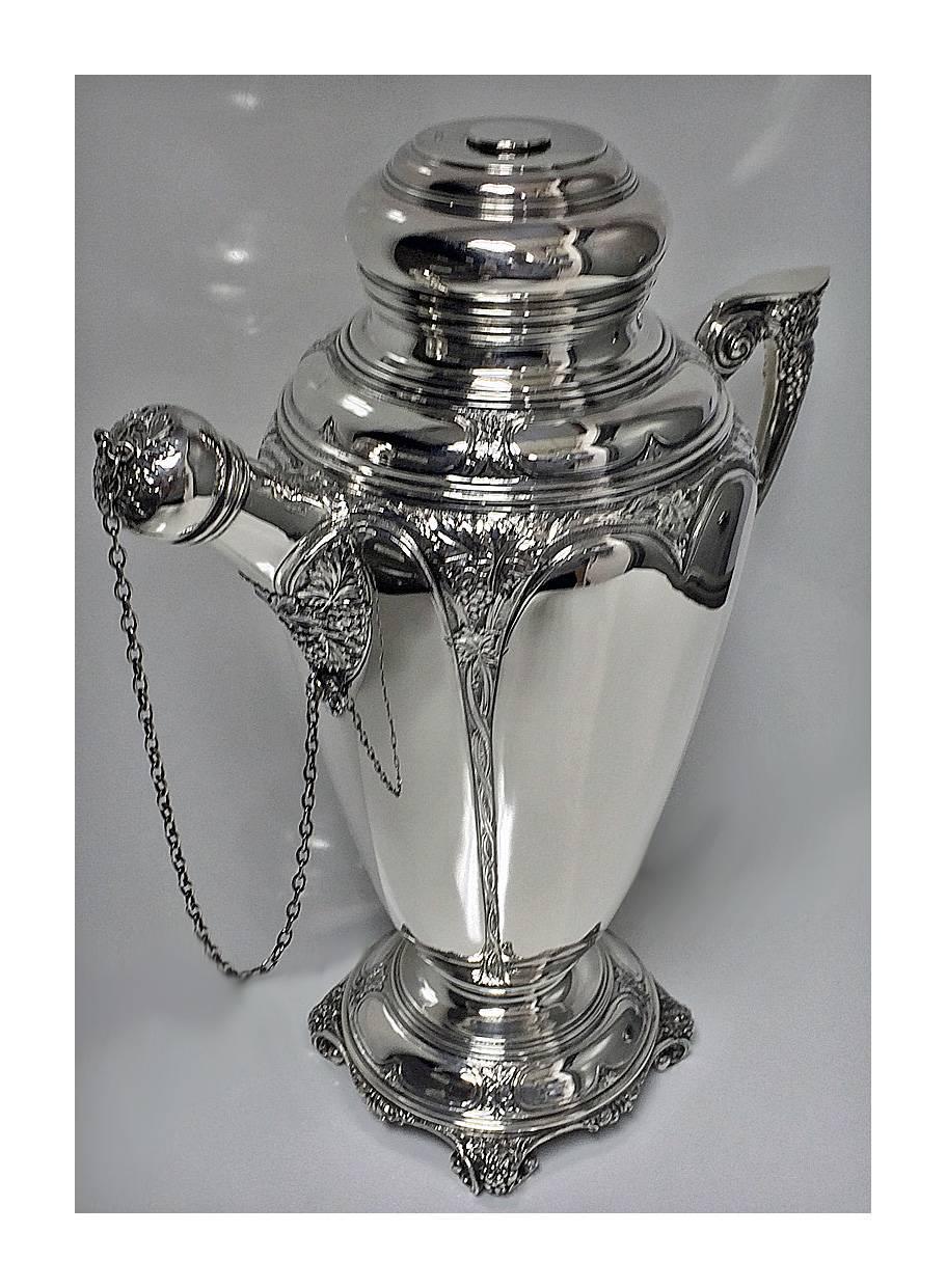 Fine Silver Cocktail Shaker, Birmingham 1928, Turner & Simpson. The Shaker on scroll and floral supports, the body of tapering cylindrical form chased with foliage, scroll and berry motifs, removable plain circular dome shaped cover with cork and